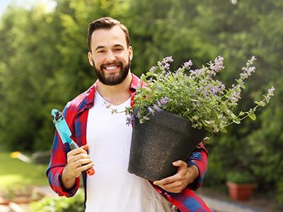 Ein junger Mann unterstützt bei der Gartenpflege für Senioren